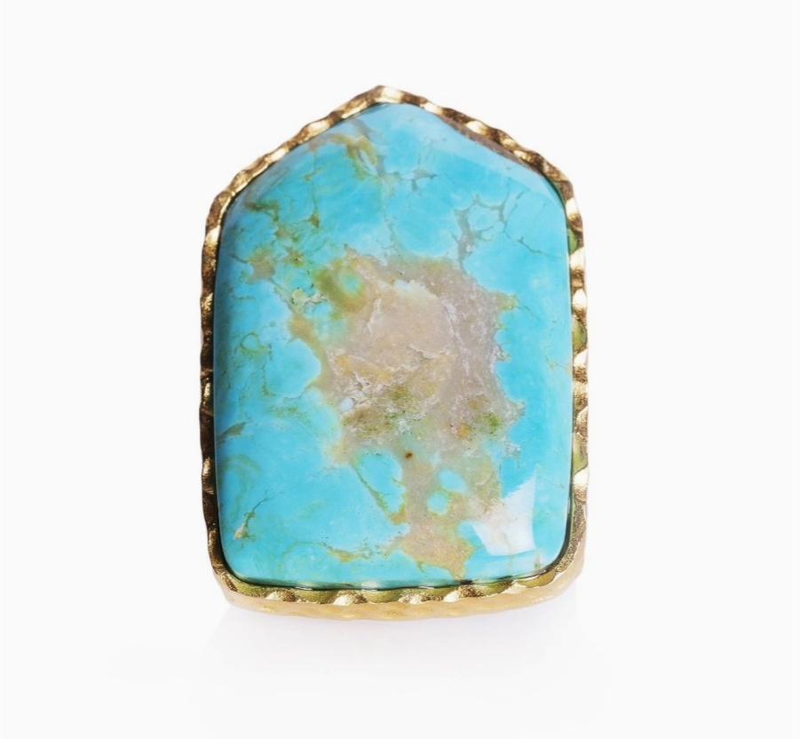 close up of a turquoise ring cut into a shield shape and placed in an 18K gold-plated sterling silver.